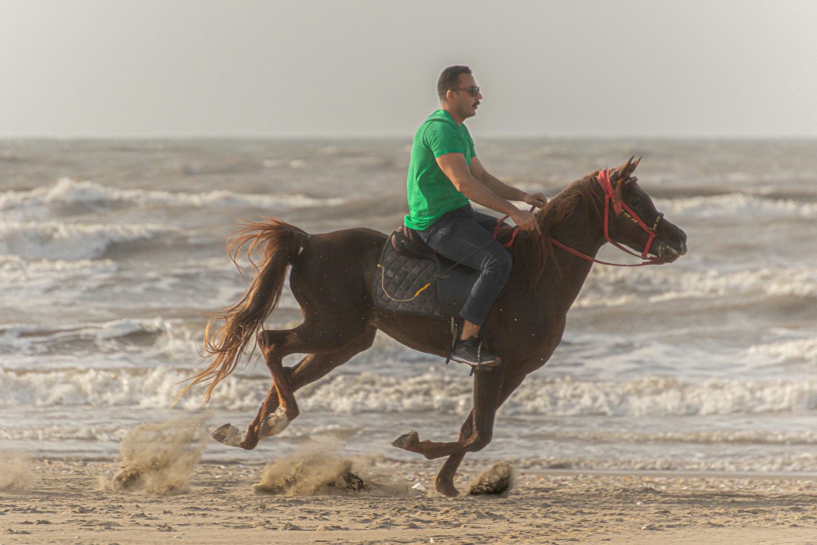 a man riding a horse on the beach